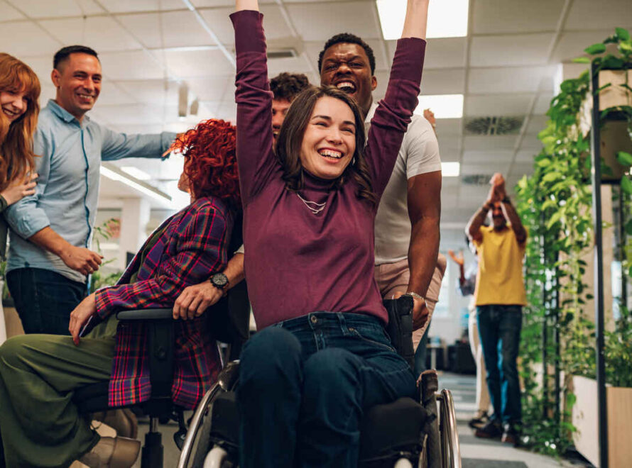 Portrait of a smiling woman with disability who won a office chair race | NDIS Core Supports Benefits - SIL Supported Independent Living