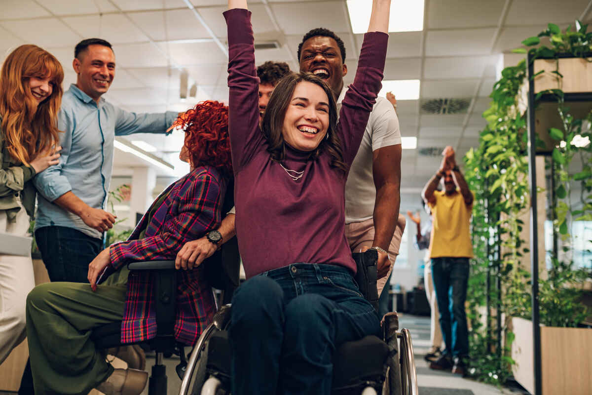 Portrait of a smiling woman with disability who won a office chair race | NDIS Core Supports Benefits - SIL Supported Independent Living